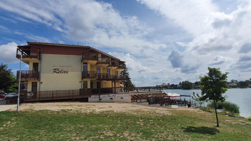 a building on the side of a lake at Apartmánový Wellness Garni Hotel Relax in Senec