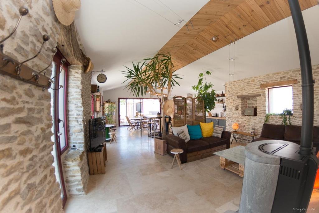 a living room with a stone wall at Longère pierres/modernité proche mer/la guittière in Talmont