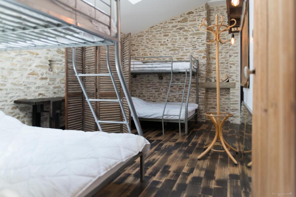 a room with two bunk beds and a desk at Longère pierres&#47;modernité proche mer&#47;la guittière in Talmont