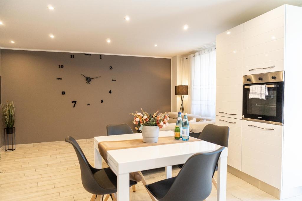 Un comedor con una mesa y sillas y un reloj en la pared. en Flow Apartments Trogmann, en Merano