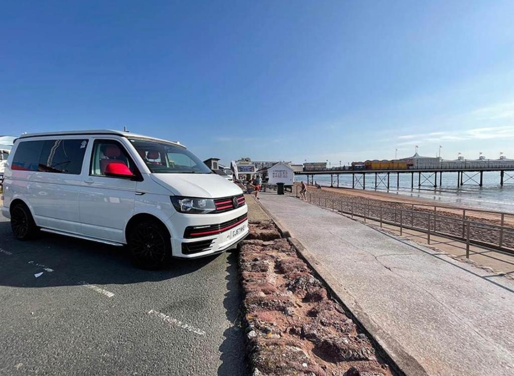 a white van parked on a road next to the beach at ChillDayz in Paignton