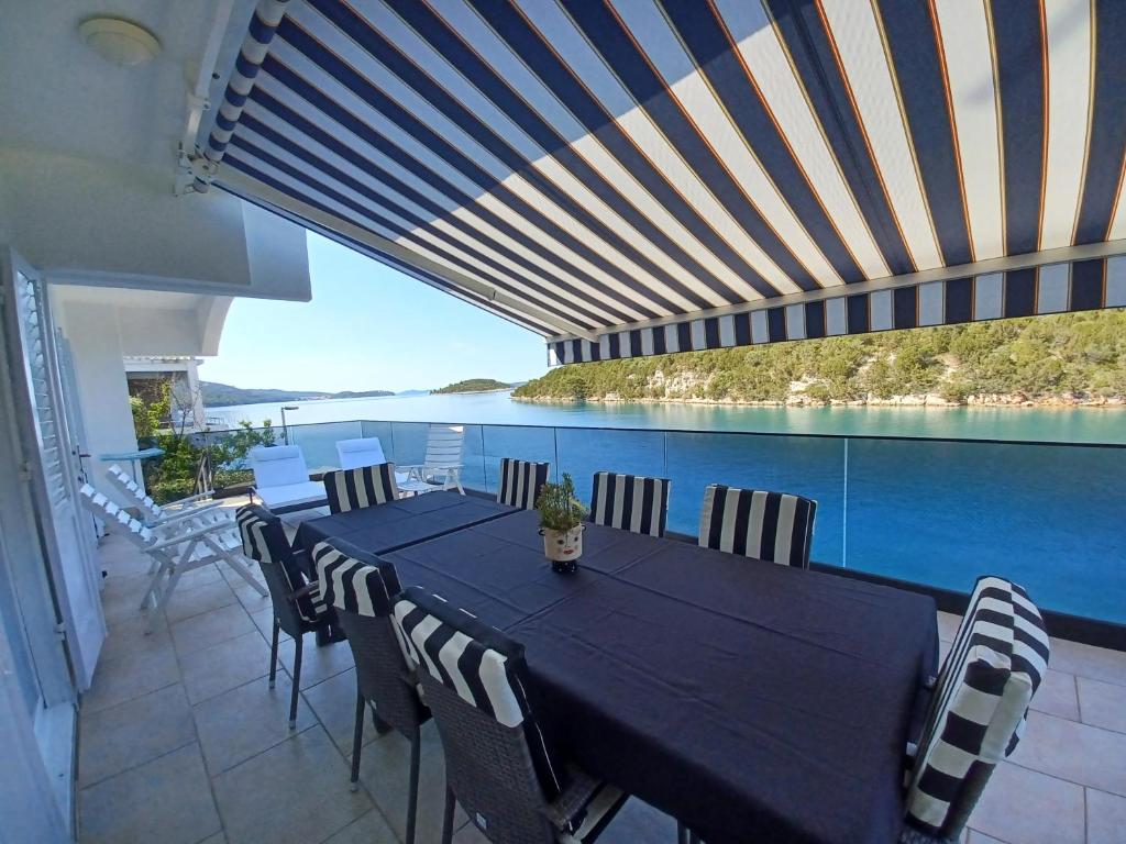 a dining room with a table and a view of the water at Vacation Home Vidučić in Dragove