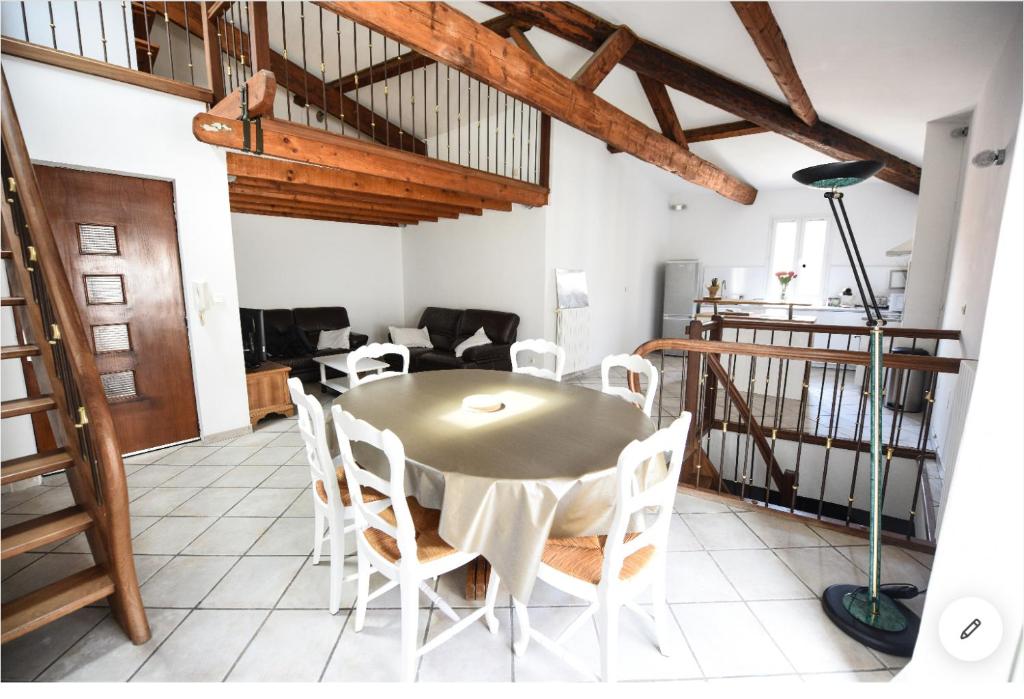 a dining room with a table and white chairs at Sète - LOFT 6 personnes. CENTRE VILLE / PORT in Sète