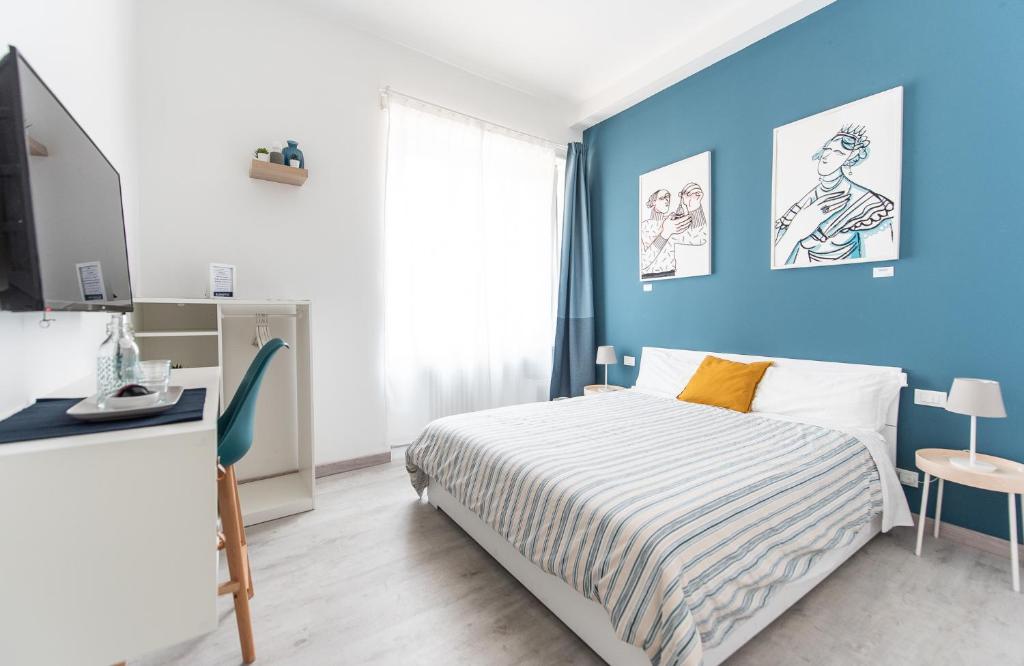 a bedroom with a bed and a blue wall at Blunotte Torino - Piazza Arbarello in Turin