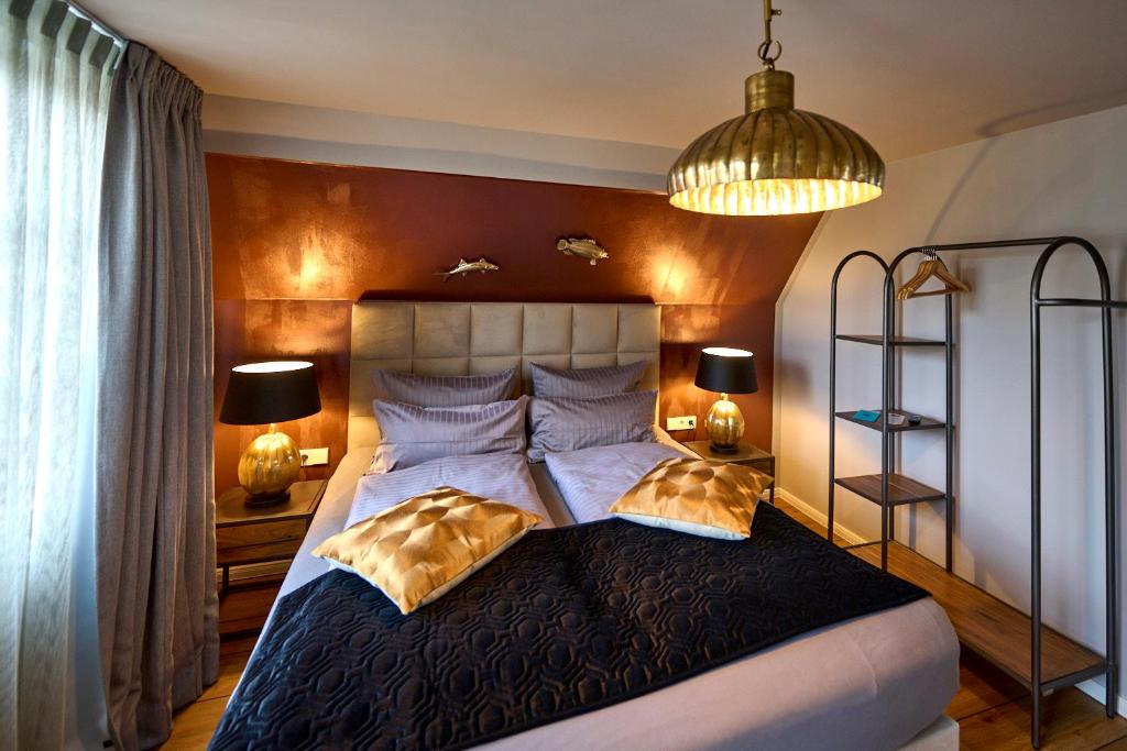 a bedroom with a large bed with two pillows at Hotel Belvedere in Warnemünde