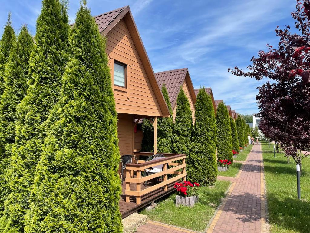 a house surrounded by trees and a sidewalk at Domki na Morskiej in Łukęcin