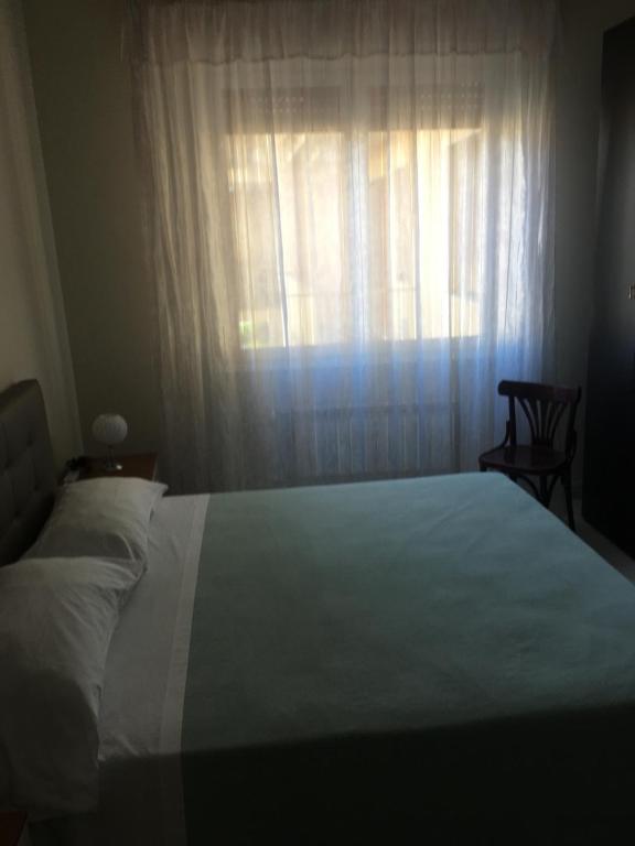 a bedroom with a white bed and a window at APPARTAMENTO SILVI in Ventimiglia