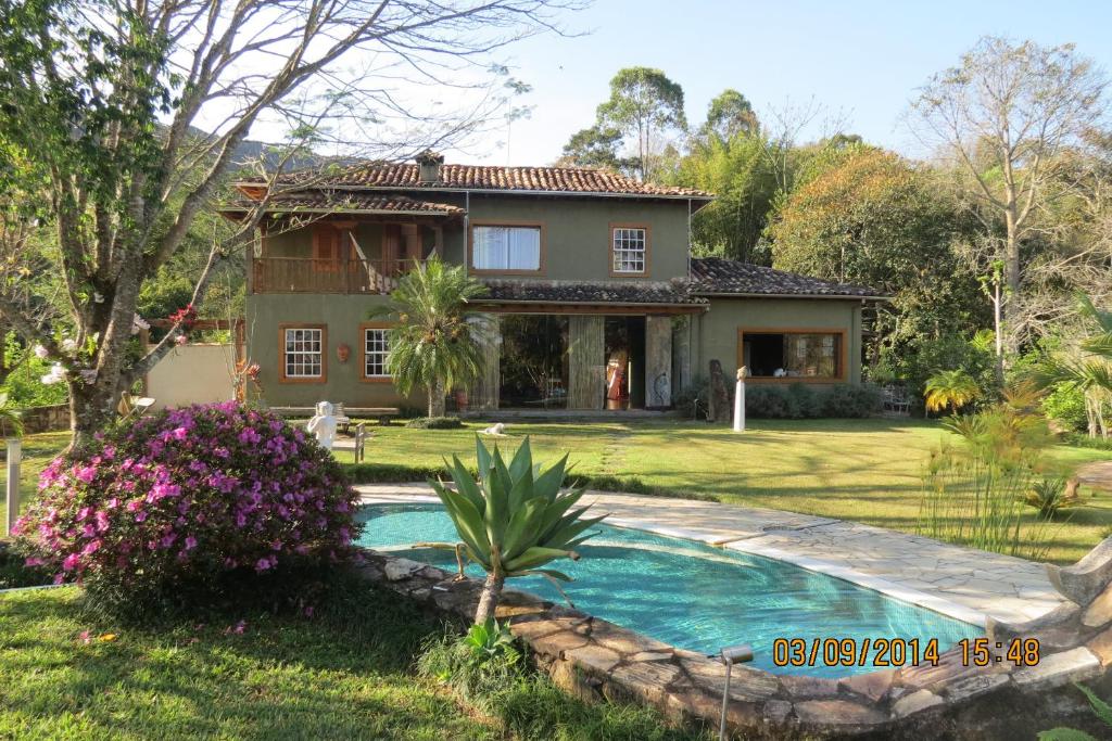 una casa con piscina frente a un patio en Pousada Casa das Fontes, en Tiradentes