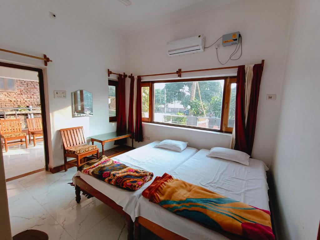 a bedroom with a bed and a large window at The Gupta Guest House in Bodh Gaya