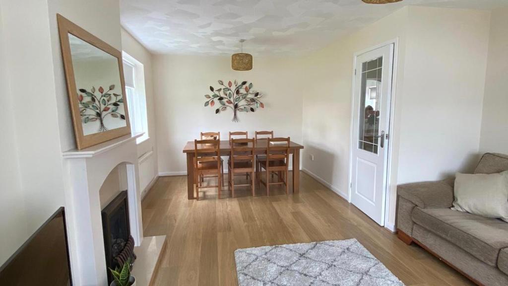 a living room with a table and chairs and a couch at Isle of Anglesey Spacious Home in Llanfairpwllgwyngyll