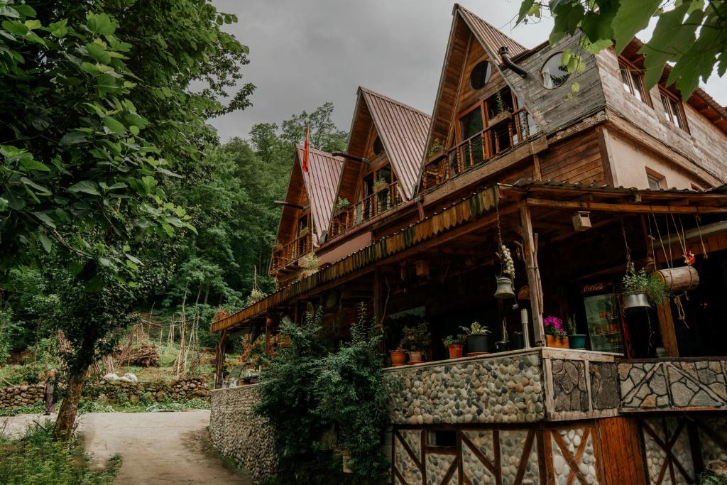 a large wooden house with potted plants on it at Moromu Bungalows in Çamlıhemşin