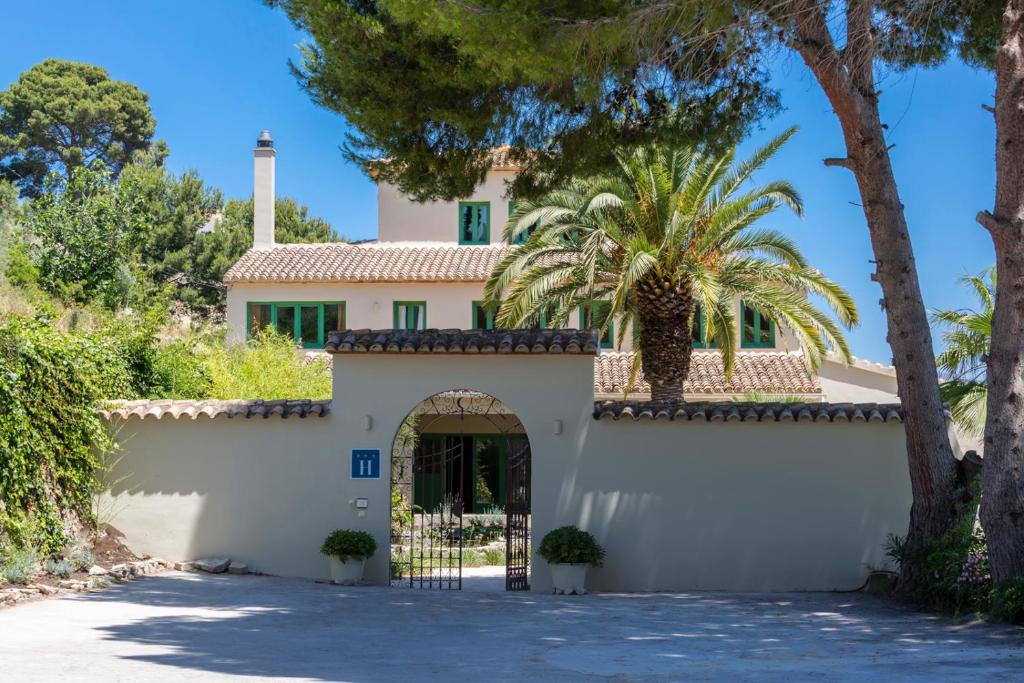 una casa con una puerta y palmeras en Villa Riu Blanc en Benissa