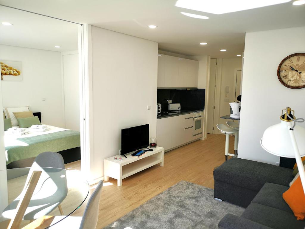 um quarto com uma cama e uma sala de estar com um espelho em OportoView Prestige Apartment no Porto