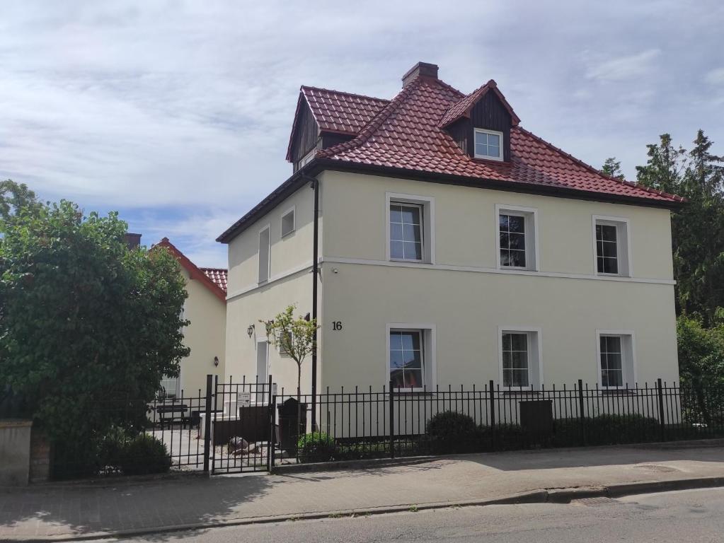una casa bianca con tetto rosso di Willa Dilla a Ustronie Morskie