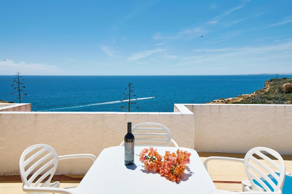 - une table avec une bouteille de vin et des fleurs dans l'établissement Apartment Rui, à Carvoeiro