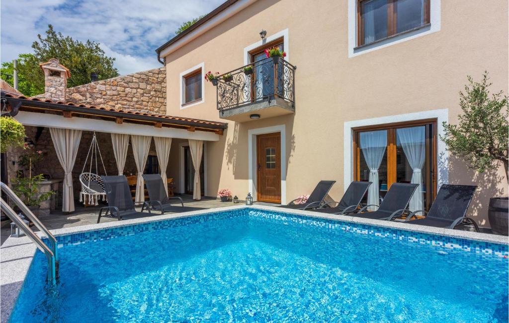 a swimming pool in front of a house at Lovely Home In Grizani With Kitchen in Grižane