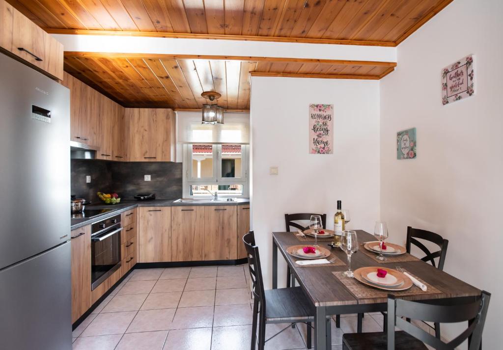 y cocina con mesa, sillas y nevera. en Melas Home, en Lefkada
