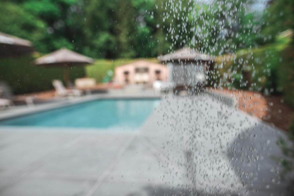 a water fountain in front of a swimming pool at Hotel Au Coeur de Lacuisine in Florenville