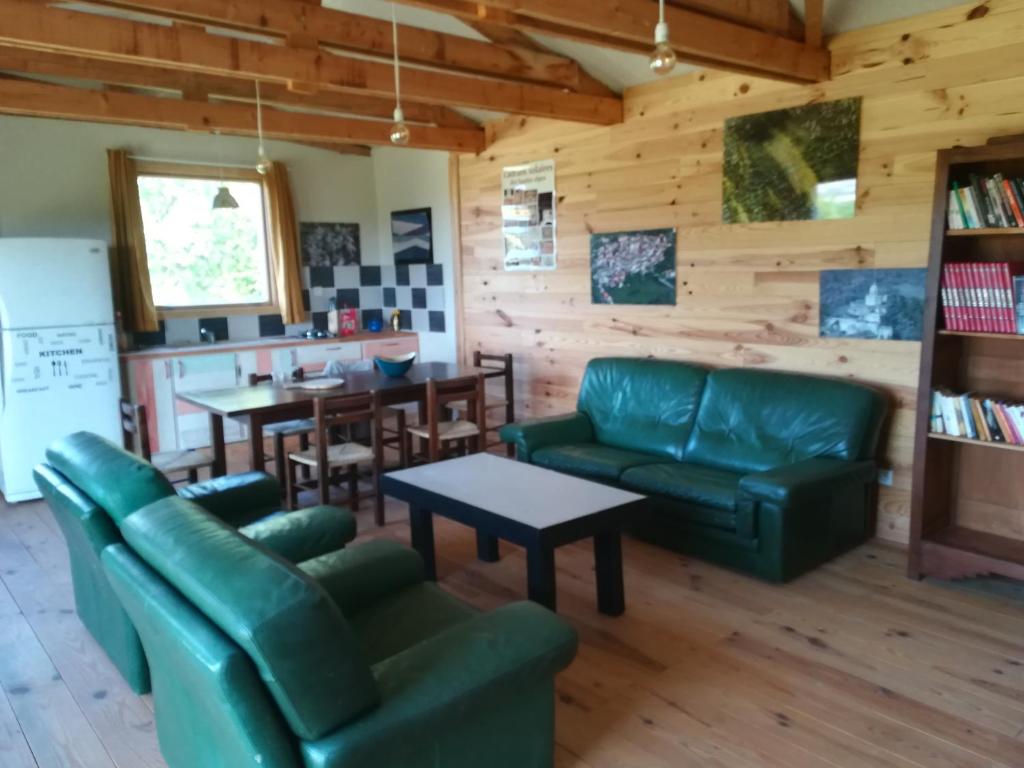uma sala de estar com mobiliário de couro verde e uma mesa em Hébergement naturel em Sigonce