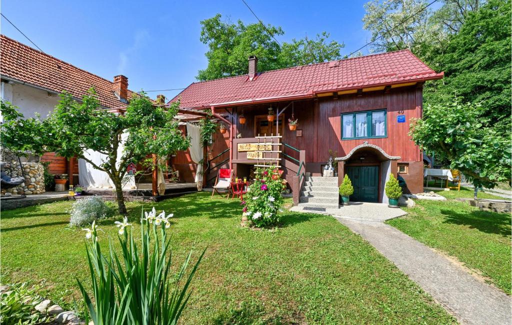 a red house with a red roof and a yard at Cozy Home In Gornja Konjscina With Wifi in Hrašćina