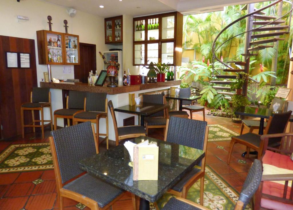 a restaurant with tables and chairs and a bar at Hotel Casa do Amarelindo in Salvador