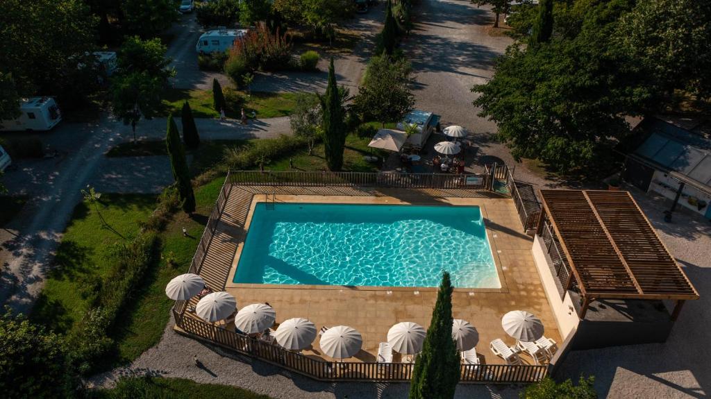 - une vue sur la piscine bordée de parasols dans l'établissement Camping Beau Rivage, à Navarrenx