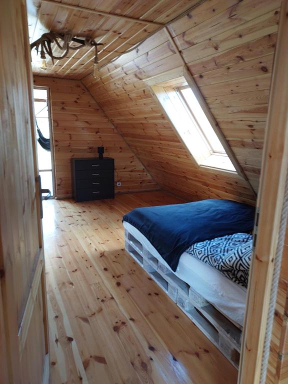 a bedroom with a bed in a wooden cabin at Oaza spokoju in Ramsówko