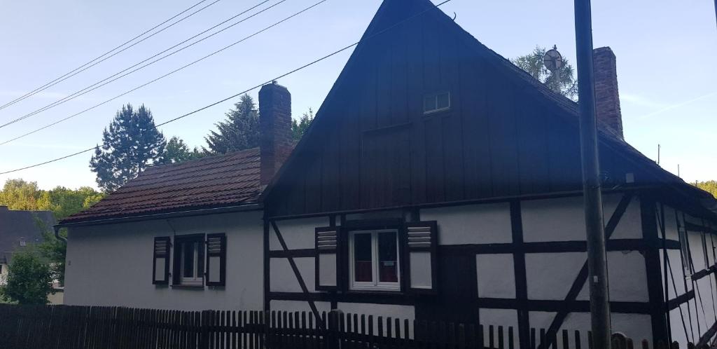una casa blanca y negra con techo negro en Ferienwohnung MAI, en Glauchau