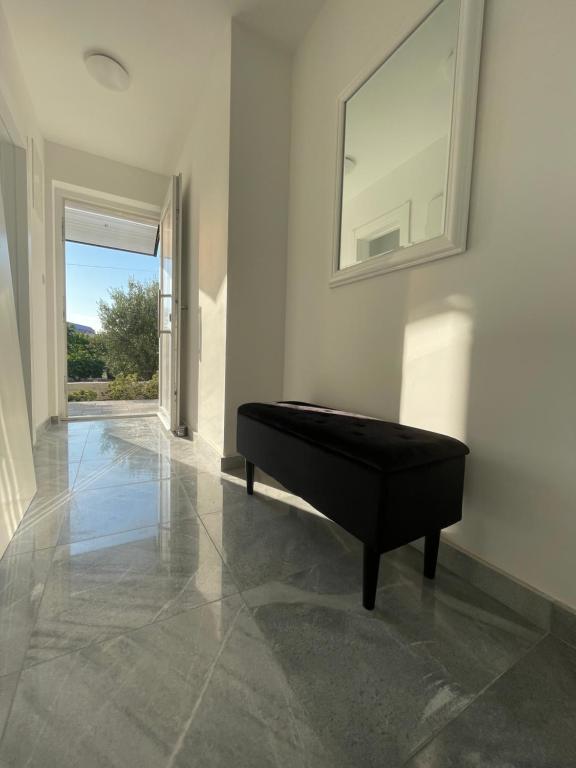 a black piano in a white room with a mirror at Vila Regina Apartment Rex with Swimming Pool in Jezera