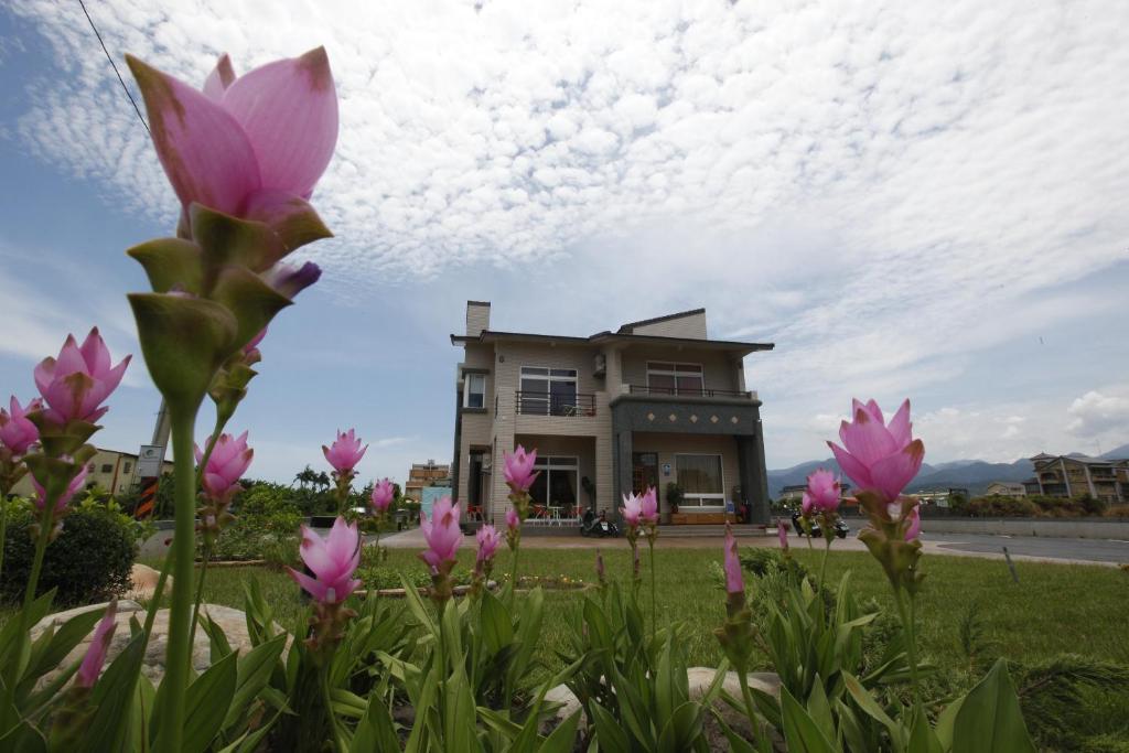 una casa con flores rosas delante de ella en Jing Xiang Hua Nong B&B en Dongshan