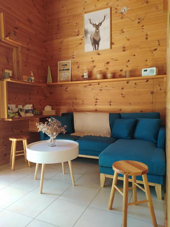 a living room with a blue couch and a table at Le Carré de Bois in Briançon