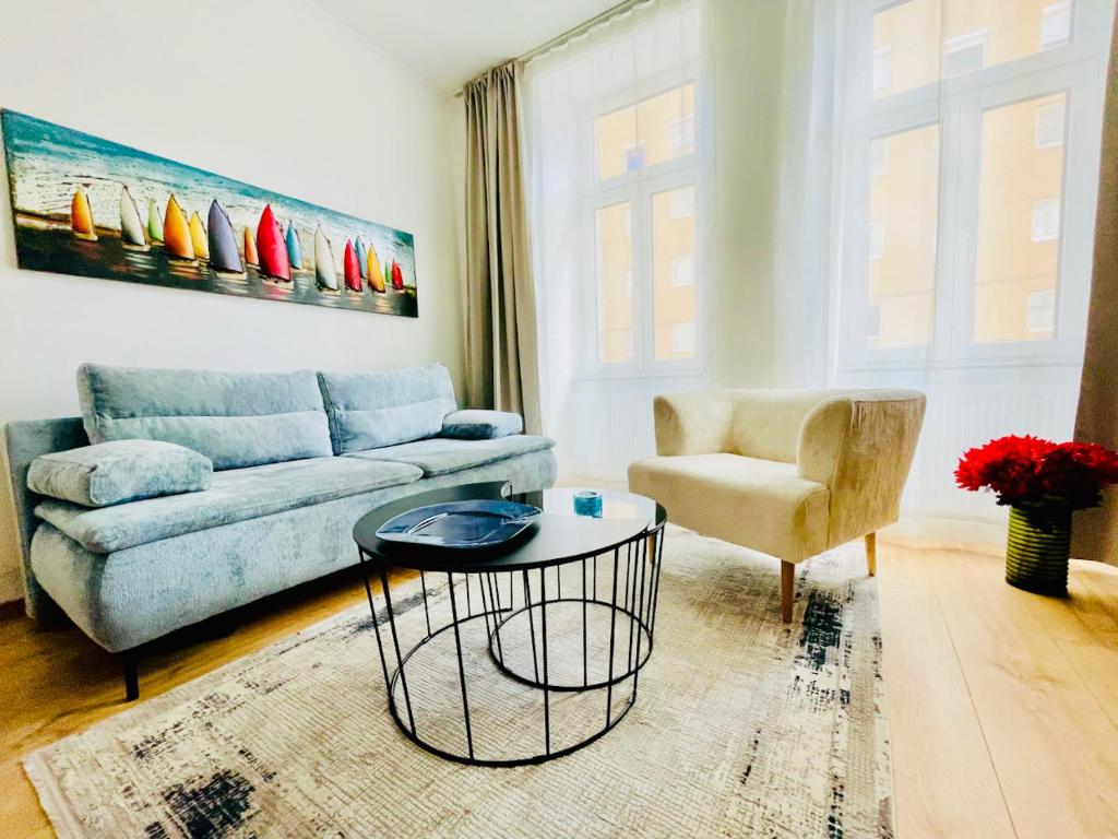 a living room with a blue couch and a chair at Colorful & Quiet Apartment in Beautiful Viennese Building in Vienna