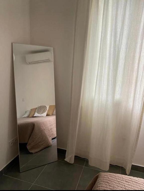 une petite pièce avec un miroir et un rideau blanc dans l'établissement Superbe appartement Corte, à Corte