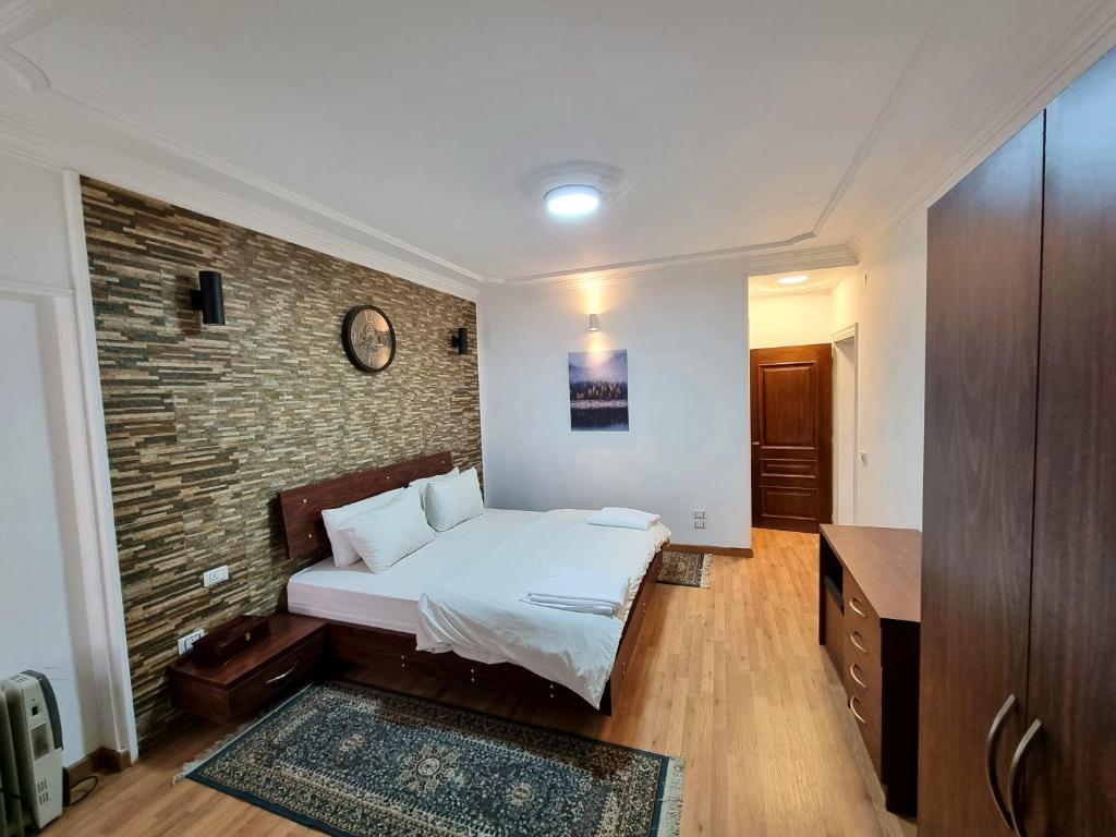 una camera da letto con un letto e un muro di mattoni di Amazing Nile View and Pyramids Apartment a Il Cairo