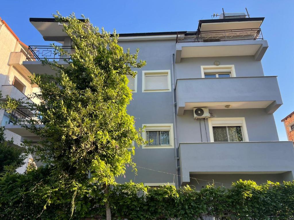 un bâtiment avec un arbre devant lui dans l'établissement Vivo Apartment, à Durrës