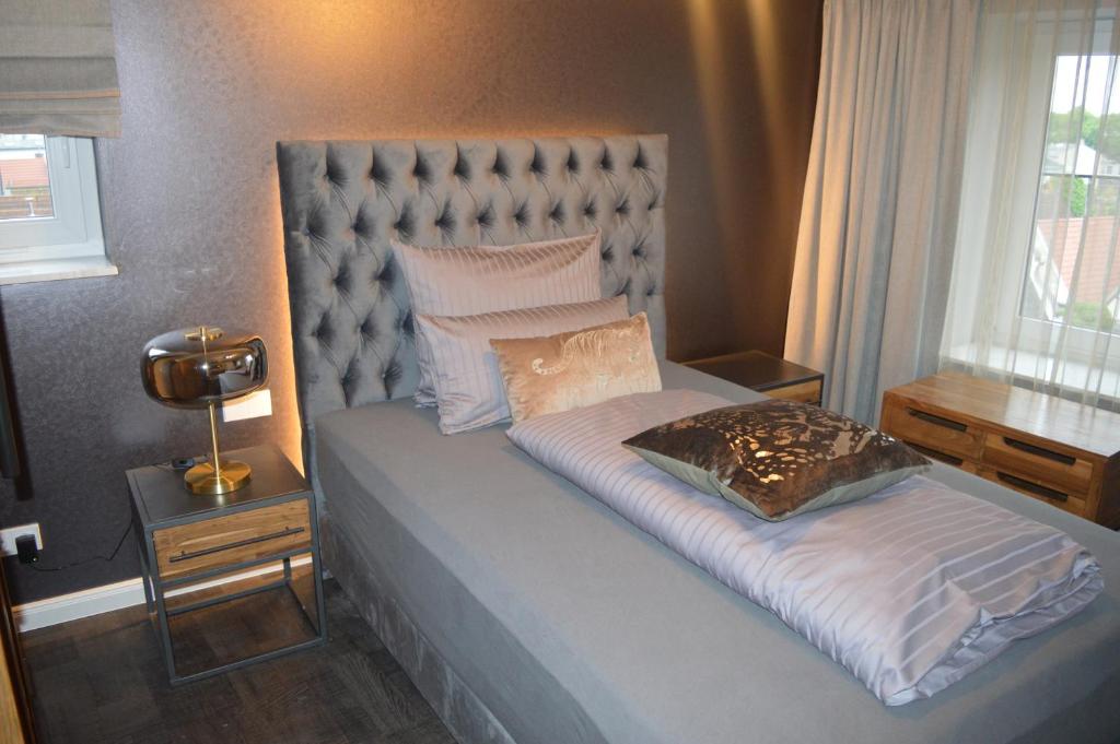 a bedroom with a bed with a headboard and a window at Hotel Belvedere in Warnemünde
