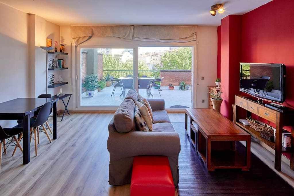 uma sala de estar com um sofá, uma mesa e uma televisão em Apartamento con gran terraza en Girona em Girona