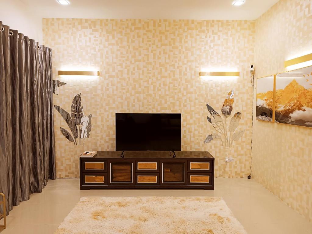 Amazing 4 bedroom townhouse with ample parking في Kota Samarahan: غرفة معيشة مع موقد وتلفزيون