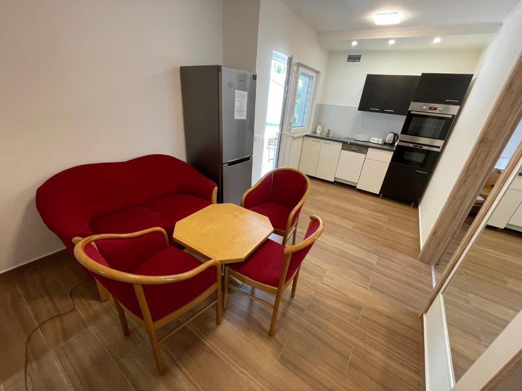 una cucina con tavolo, sedie e frigorifero di Liget Üdülőpark Fonyód a Fonyód