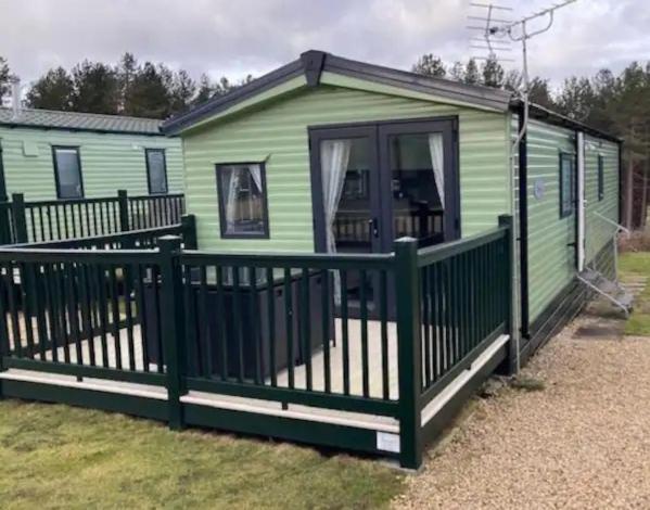 a green tiny house with a green fence at Liberty-5 in Slaley