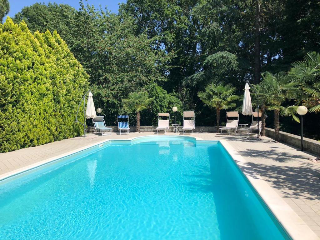 una grande piscina con sedie e ombrelloni di 3 bedrooms villa with private pool enclosed garden and wifi at Tuoro sul Trasimeno 2 km away from the beach a Tuoro sul Trasimeno
