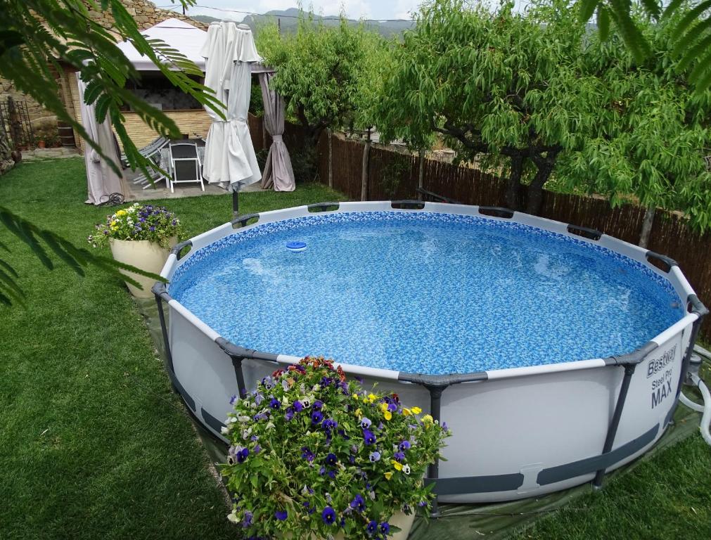 a large swimming pool in a yard with flowers at Casa L'Apargatero in Morillo de Monclús