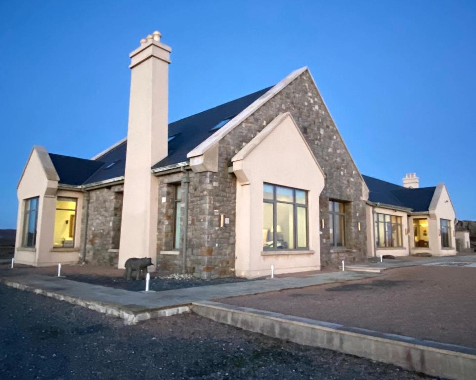 ein großes Steingebäude mit Kamin in der Unterkunft Seabrook Lodge Clifden Connemara in Clifden