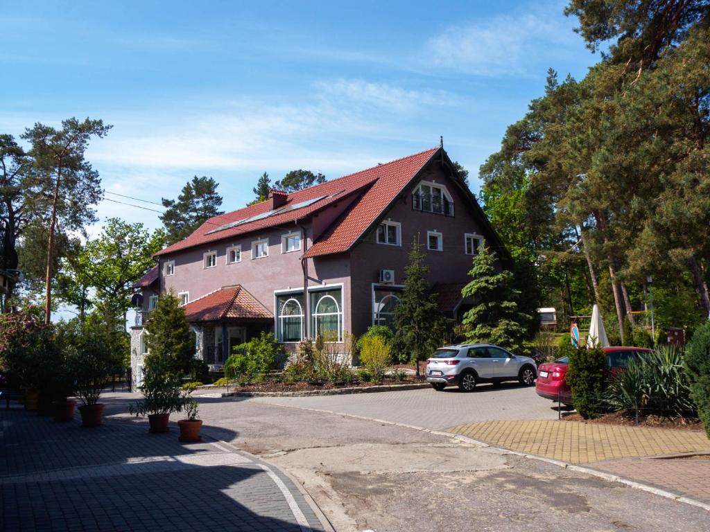 a house with a car parked in front of it at "Apollo" - domek, apartamenty i pokoje z klimatyzacją in Krynica Morska