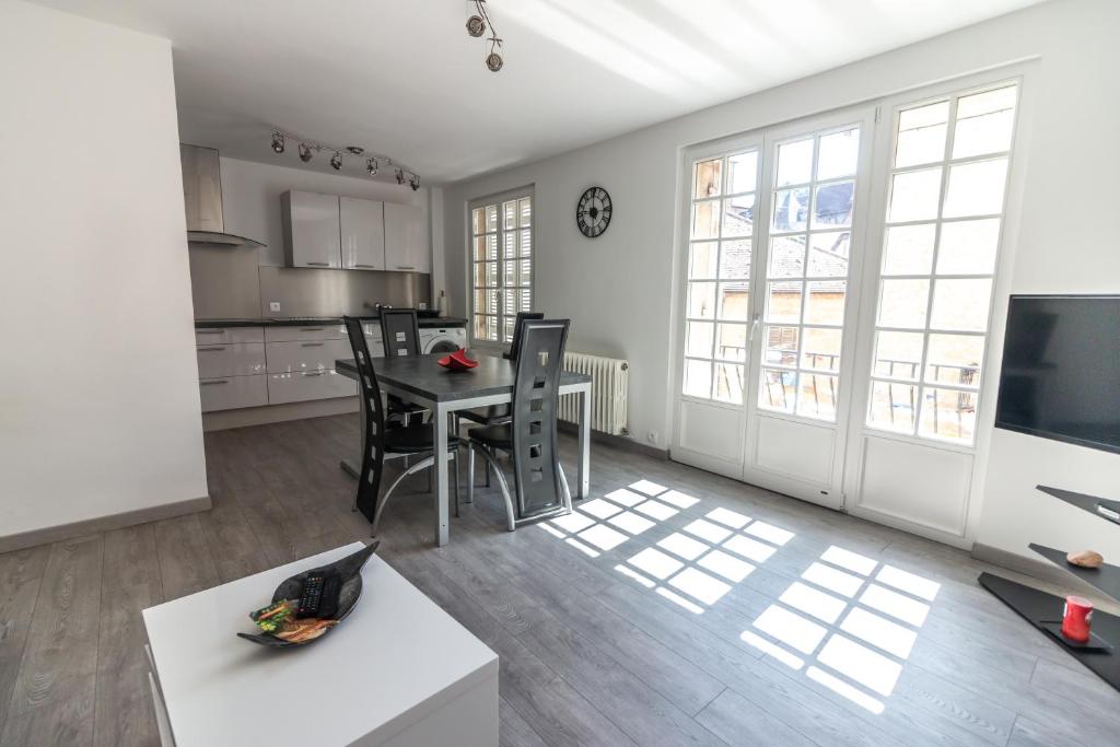 une cuisine et une salle à manger avec une table et des chaises dans l'établissement La Salamandra au coeur de Sarlat, à Sarlat-la-Canéda