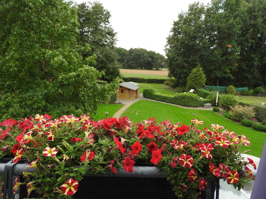 una caja de ventanas con flores rojas en un jardín en Appartement im Schlösschen Nr. 2 mit Balkon en Willich