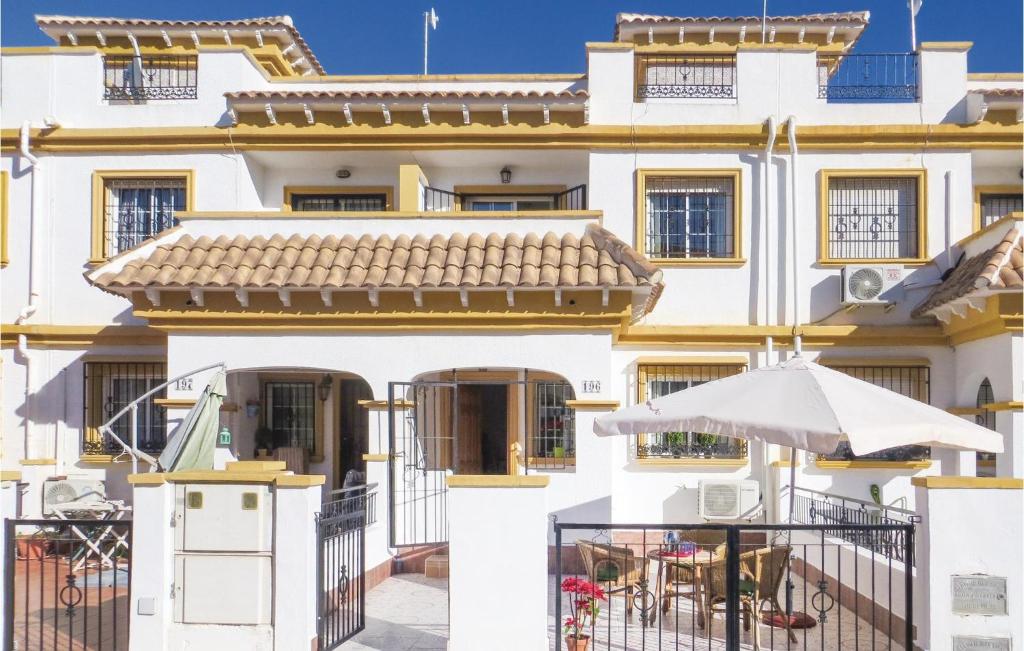 a white building with a balcony and an umbrella at Cozy Home In Torrevieja With Wifi in Torrevieja