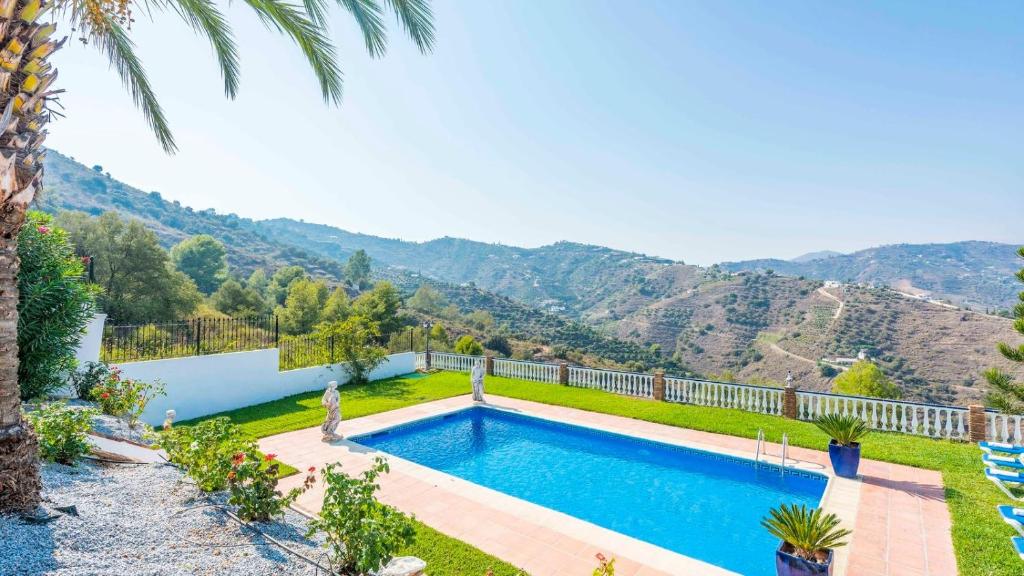 uma piscina num quintal com montanhas ao fundo em Casa Rural Cortijo Picuales Torrox by Ruralidays em Torrox
