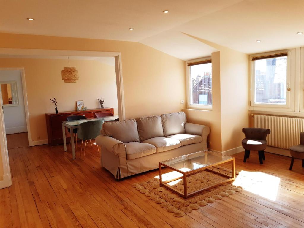 een woonkamer met een bank en een tafel bij Appartement Malo les Bains à deux pas de la plage in Duinkerke