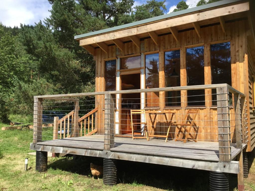 a tiny house on a platform in a field at Caledonian Glamping in Cannich